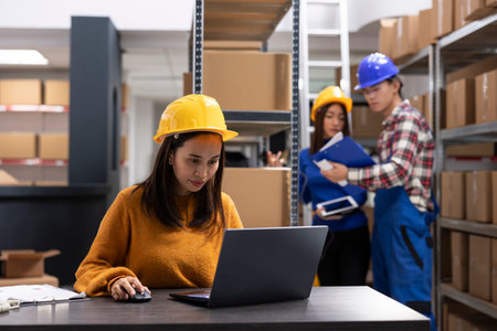 Female worker at small business depot ensures products ready for local delivery. Storage, packaging and shipping services are handled in house for small scale distribution efficiency.の写真素材
