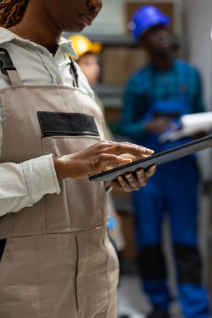 African american employees manage packages and crates in import export depot, logistics system supports manufacturing processes, order tracking and product shipment preparation.の写真素材