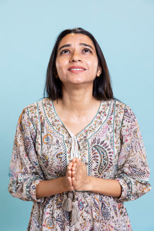 Religious indian girl praying to god and showing optimism on camera, talking to jesus with respect...