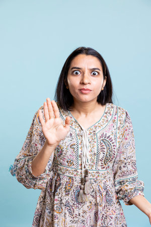 Serious irritated person raising her palm and refusing something, showing rejection and denial...
