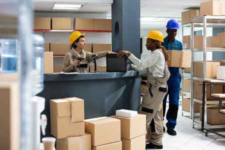 Small business diverse workers manage orders and scans packages for retail shipment and supply chain...
