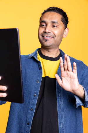 Young adult chatting on remote video conference on the digital tablet, wearing casual clothes and a...