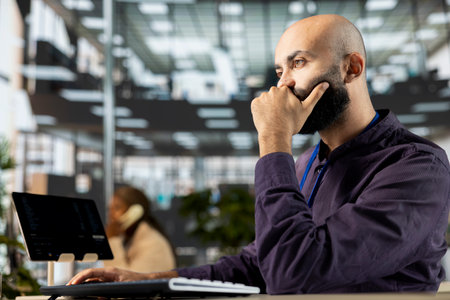 Male executive analyst finalizing a report and reviewing online data, developing a financial...