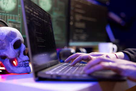 Close up of person using laptop to bypass firewalls, launching DDoS attacks. Man typing on notebook...