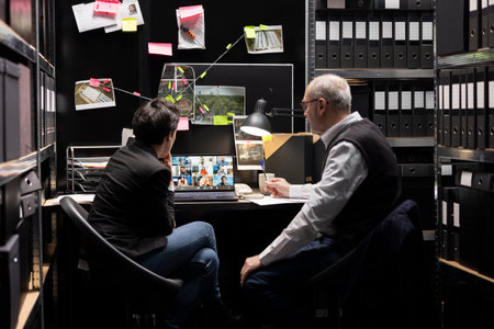 Law enforcement agents discuss clues with witnesses on remote video call in an evidence room,...