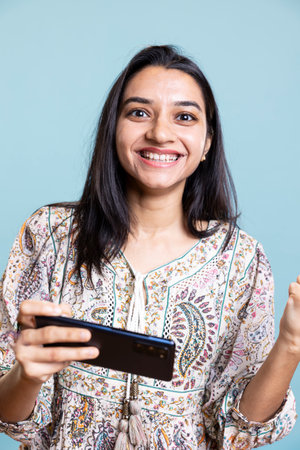 Confident pleased gamer enjoying her video gaming competition win, being proud of her skills for e...