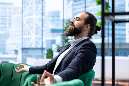 Professional leader embraces self care with sound therapy to maintain balance. Entrepreneur meditating for his wellbeing to keep a successful career in a demanding business environment.の写真素材