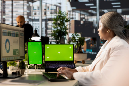 African american employee uses green screen and evaluating performance metrics, working with...