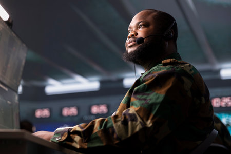 Military dispatcher in control center relays information from army intelligence analysts to troops...