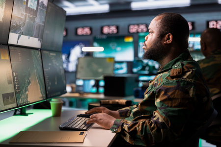 Combat specialist working in governmental facility operating as surveillance monitoring center filled with digital equipment. Intelligence corps doing job in base of operationsの写真素材