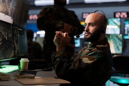Military dispatcher in war room ready to respond to emergencies and communicate with soldiers on...
