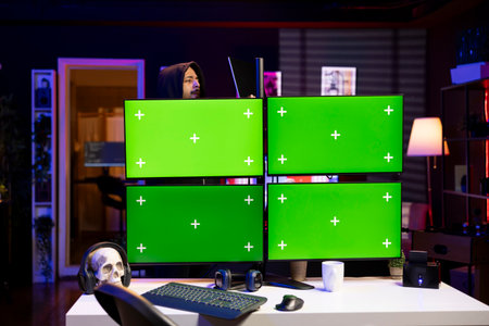 Hacker using chroma key PC displays, coding malware designed to exploit network backdoors. Rogue...