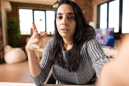 Indian female professional uses cellphone to record friendly video blog, presenting entrepreneurial...