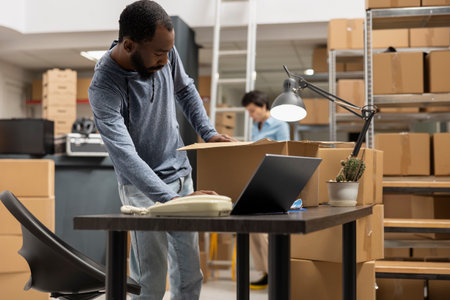 Black male staff verifying custom orders logistics and product handling, working at a fulfillment...