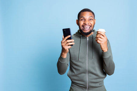 Confident relaxed person texting his friends and serving fresh cup of coffee, feeling happy and...