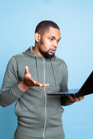 Male person smiling and waving at his friends on videoconference call, meeting with pals and having...