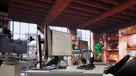 Empty AI tech agency workspace providing custom software development services. Machine learning technology running on PC in startup office to streamline coding process, handheld camera shotの写真素材