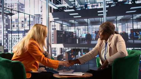 Female executives review legal paperwork and finalizing an important deal, signing banking documents...