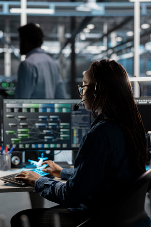 IT specialist in data center looking at node trees, providing technical support to customers. Server...