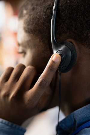 Call center agent speaks with customer using audio headset, adhering to company communication...