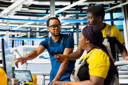 African american team of technicians doing quality control on pc, troubleshooting and fixing...