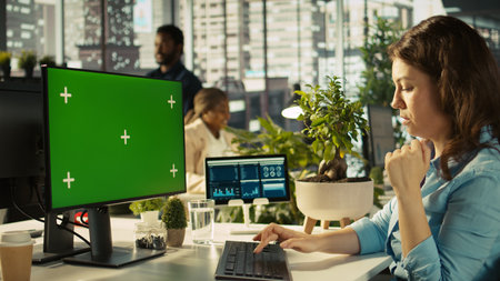 Office clerk working on isolated screen PC to hit key performance targets for revenue and...