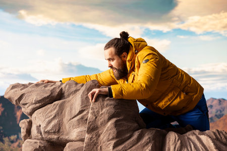 Hiker stumbles near the edge of a high altitude cliff, caught off guard by strong winds. Unequipped...