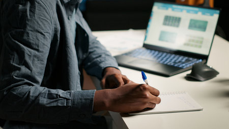 Remote job professional at his personal office balancing activities like research, writing notes and...