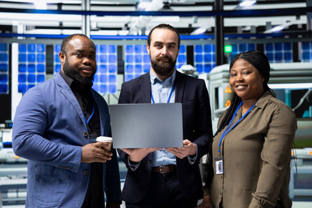 Portrait of diverse master engineers in suits managing solar panel systems as part of a...