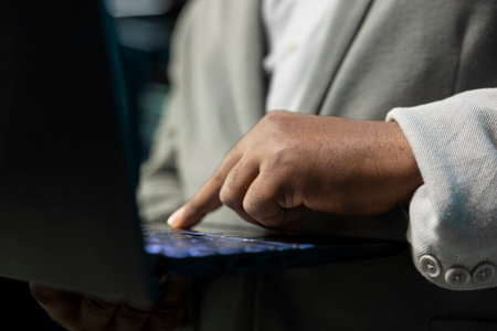 Close up of programmer in data center typing on notebook keyboard, writing lines of code. Server...
