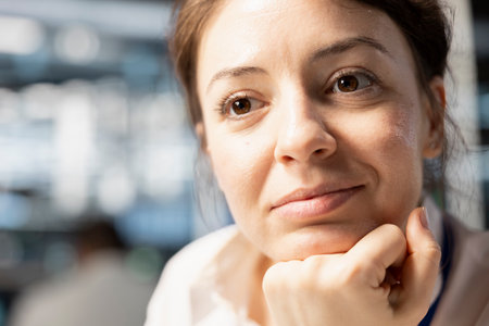 Close up of smiling data center IT professional monitoring system performance, identifying bottlenecks. Woman in server farm troubleshooting computer bugs, implementing optimizationsの写真素材