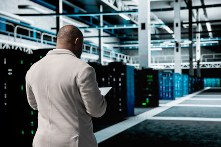 Technician in data center workspace running system diagnostic tests, increasing uptime and...