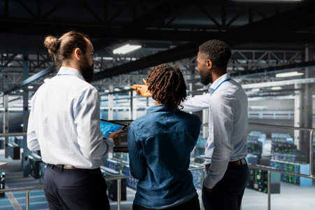 Data center staff on industrial platform collaborating to maintain servers using artificial intelligence. Engineers doing teamwork to support infrastructure AI deep learning automatization.の写真素材