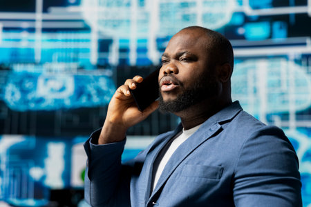 Black tech specialist talking on a smartphone call in an AI powered environment, representing...