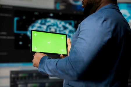 African American expert holds device with mockup screen with binary code in the background, digital transformation. Showcasing software development with algorithms, data science.の写真素材