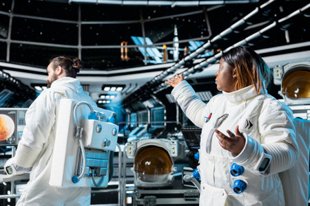 Astronaut doing video briefing with Earth based researchers, troubleshooting space station hardware. Female spaceship cosmonaut presents current mission status during internet videocallの写真素材