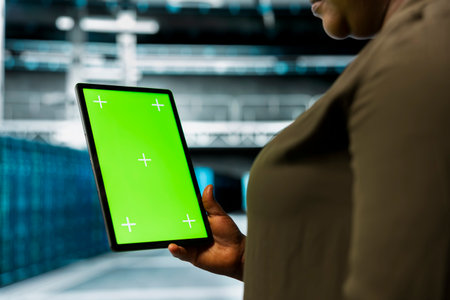 Close up of data center admin using isolated screen tablet to install equipment used for hosting...