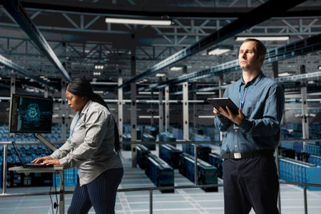 Server farm team of technicians using devices to do infrastructure AI machine learning automatization. Data center programmer and coworker doing maintenance using artificial intelligenceの写真素材