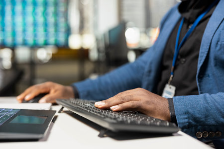 Close up of black male worker demonstrates a strategic mindset and analyzes business data with...