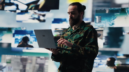 Armed forces soldier gathers surveillance from digital drone systems, preparing for combat with warfare strategies and battlefield details. War planning operations in command center. Camera A.の写真素材