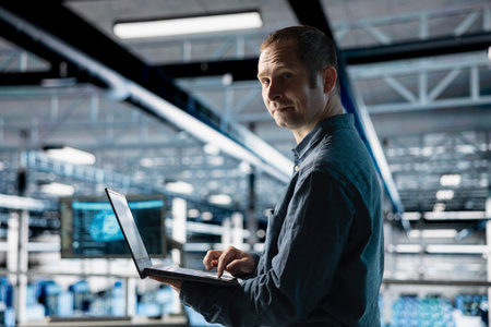 Cheerful server farm worker uses specialized hardware to accelerate complex AI calculations. Portrait of smiling engineer in data center providing computing resources and storage to enable AI trainingの写真素材