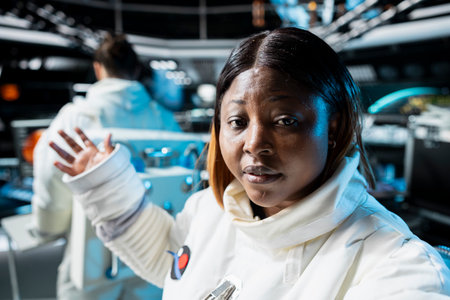 Astronaut doing personal log entry broadcasted from inside space station. Spaceship crew member sharing insights and updates during daily communication routine done for scientists on Earthの写真素材