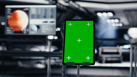 Chroma key device assisting orbit station astronauts in managing planetary observations. Isolated screen tablet in spaceship used for data input next to nearby display showing Mars mission analysisの写真素材