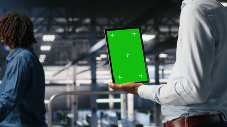 Close up of server hub admin using isolated screen tablet next to colleague reviewing AI LLM visualization. Data center employee using mockup device to monitor machine learning systemsの写真素材