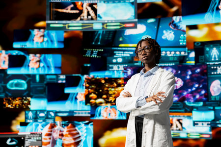 Portrait of healthcare specialist reviewing CT scans, MRI data, and lab analytics displayed on videowall. Scientist in medical research lab visualizing health data on futuristic panelsの写真素材