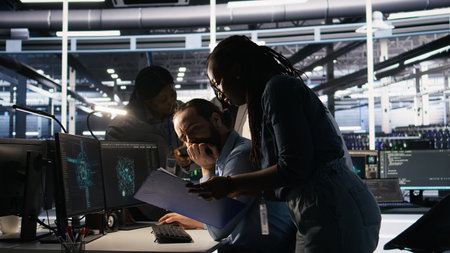 System administration team collaborating on AI automation deployment in data center. Server farm...