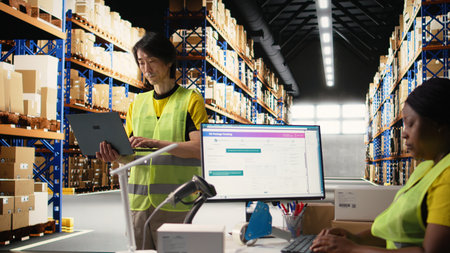 Asian industrial employee organizes goods and processes online shopping orders, coordinating...