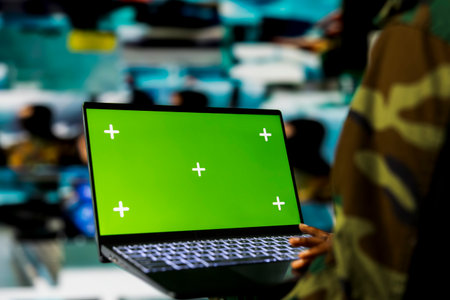 Close up of soldier in command center using green screen laptop, monitoring intelligence feeds. Armed forces expert oversees military operations in headquarters using mockup notebookの写真素材