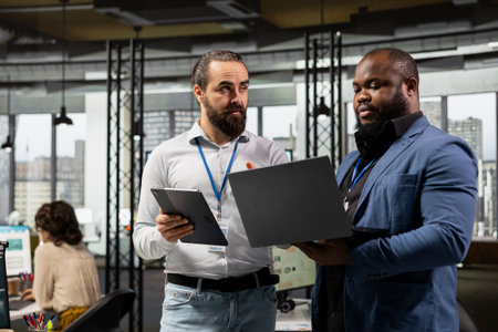 Team of diverse men work with technology and performance metrics, aligning business strategy and project objectives to drive results and success within a multinational company environment.の写真素材