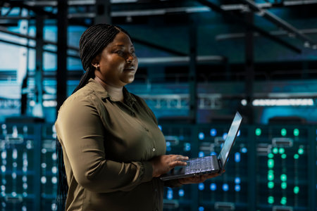 Data center engineer conducting tests on equipment using software to fix bugs. Server farm employee performing updates on infrastructure core services, refining algorithms for faster processingの写真素材